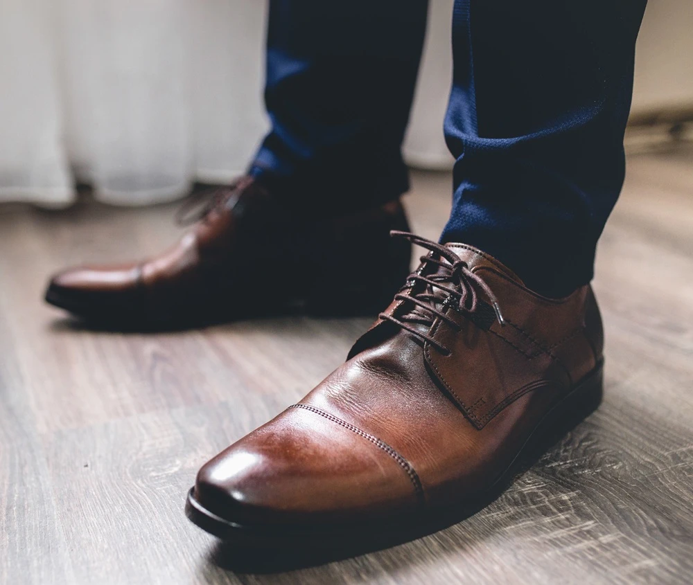 Closeup of a groomsman wearing cap toe shoes